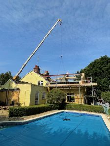 Mobile crane lifting a ridge beam into position