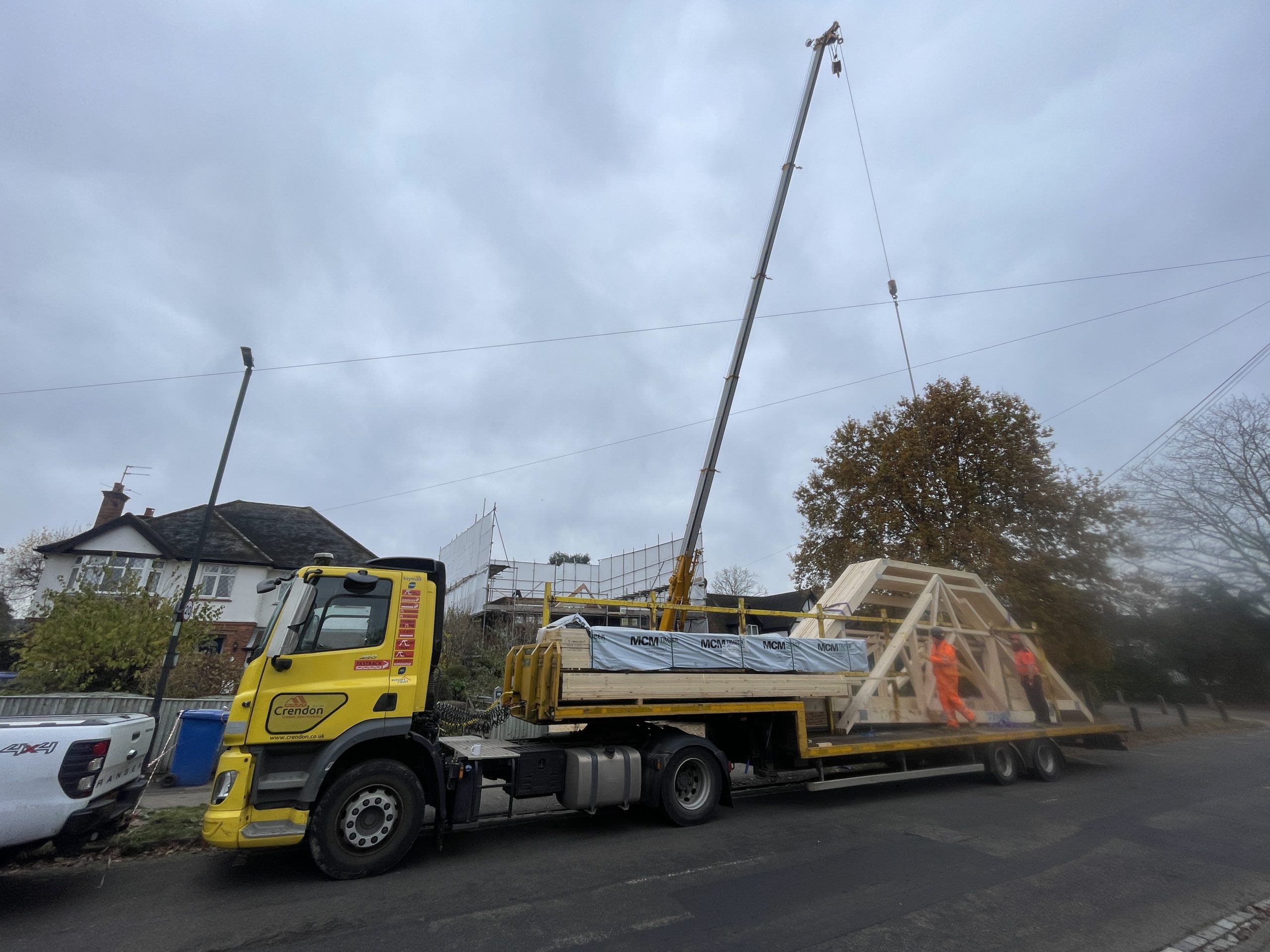 Truss lorry Mobile crane unloading roof trusses from a lorry