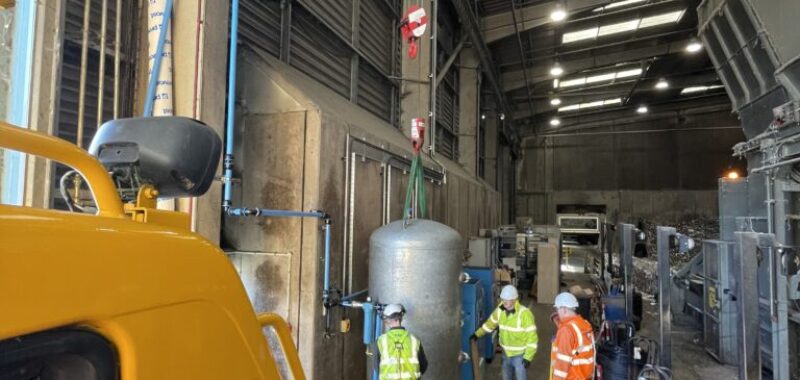 Mobile crane lifting a receiver unit inside an industrial building