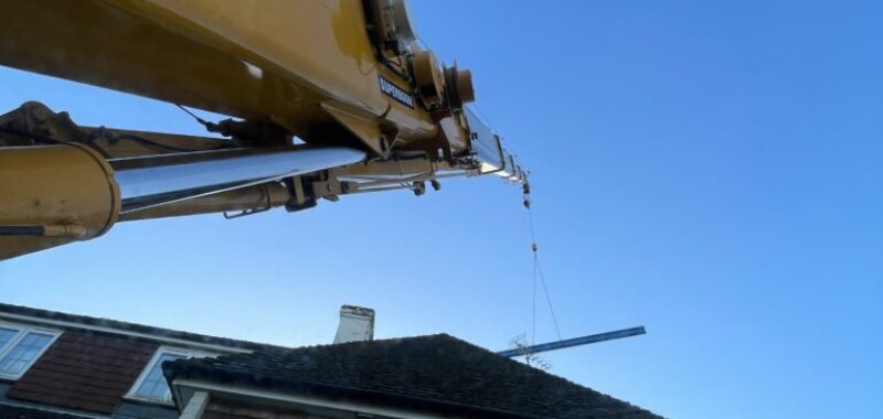 Mobile crane lifting steel for an extension.