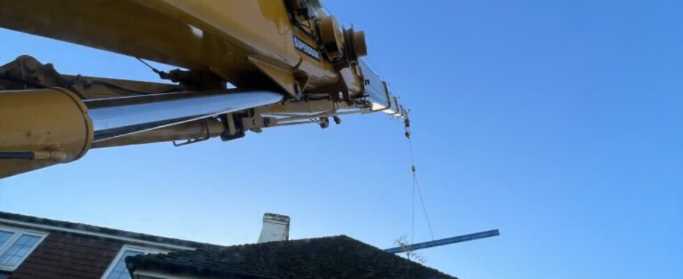Mobile crane lifting steel for an extension.