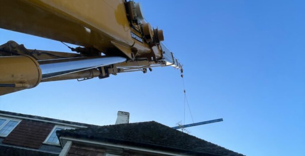 Mobile crane lifting steel for an extension.
